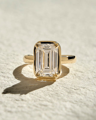 Emerald cut lab grown diamond bezel set solitaire engagement ring in white gold