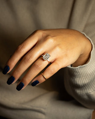 Emerald cut lab grown diamond three stone engagement ring with sleek band