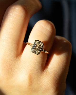 Emerald cut lab grown diamond bezel engagement ring in sleek white gold setting