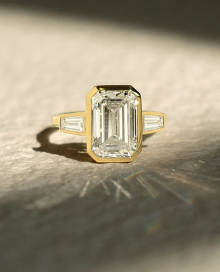 Emerald cut lab grown diamond bezel engagement ring in white gold setting