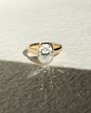 Cushion cut lab grown diamond bezel engagement ring in white gold setting