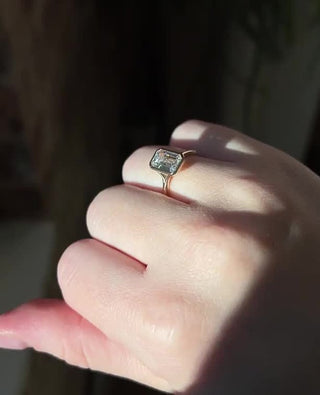 Emerald cut lab grown diamond bezel engagement ring in sleek white gold setting